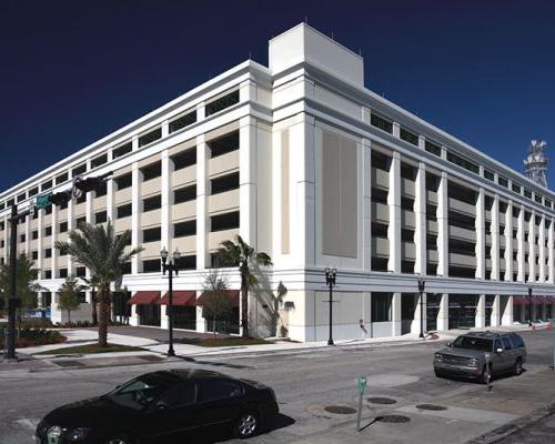 Exterior photo of the City of Jacksonville parking garage. 正午，汽车驶过.